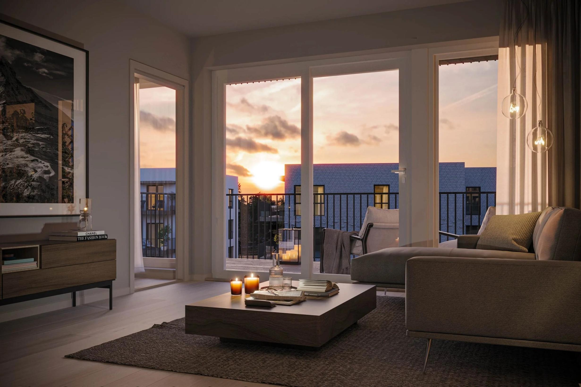 Stue i lune toner med mørk sofa, lavt bord og store vinduer med utsikt mot solnedgang og balkong.