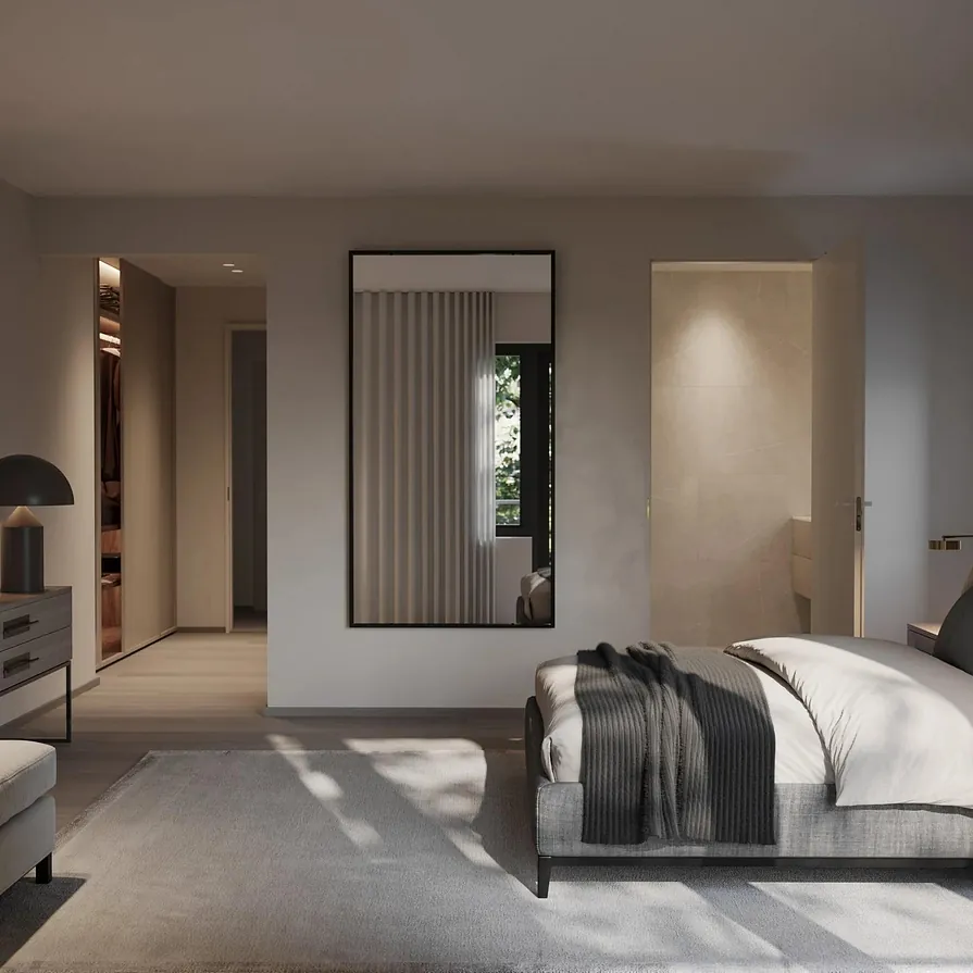 Stort soverom med dobbeltseng, mykt teppe og speil, samt inngang til walk-in og bad.