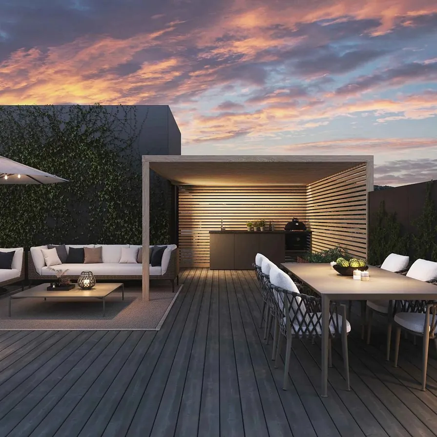 Eksklusiv takterrasse med sofagruppe, spisebord, utekjøkken og stemningsfull belysning ved solnedgang.