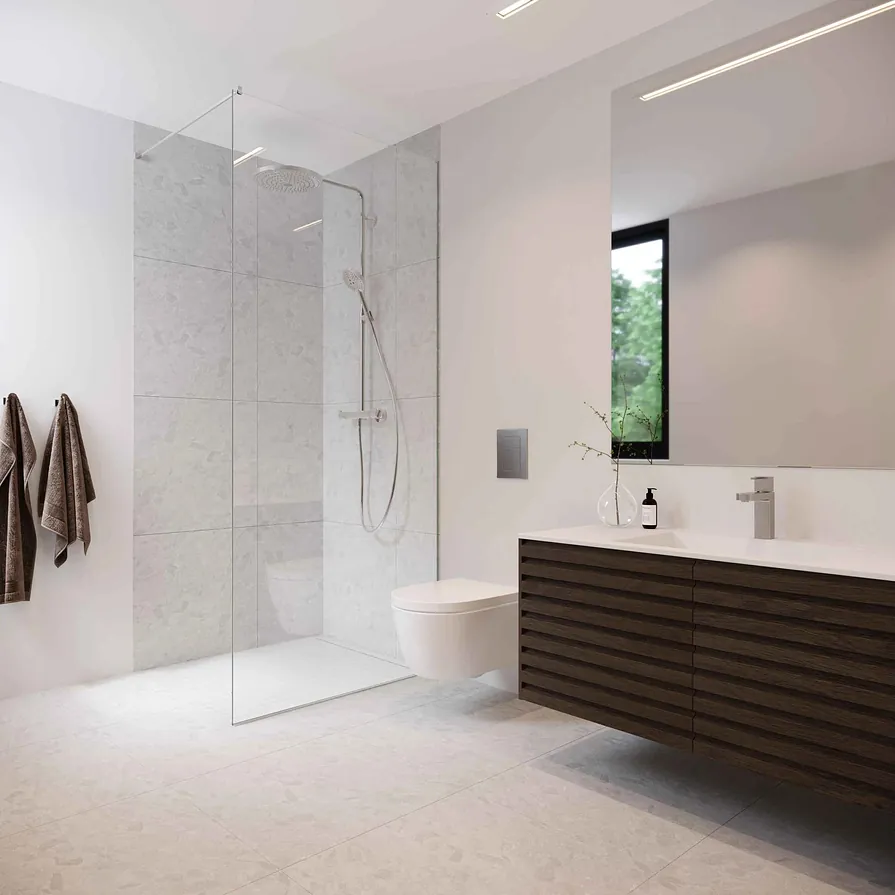 Minimalistisk bad med lyse fliser, vegghengt toalett og mørk servantskap med speil og dusjhjørne.